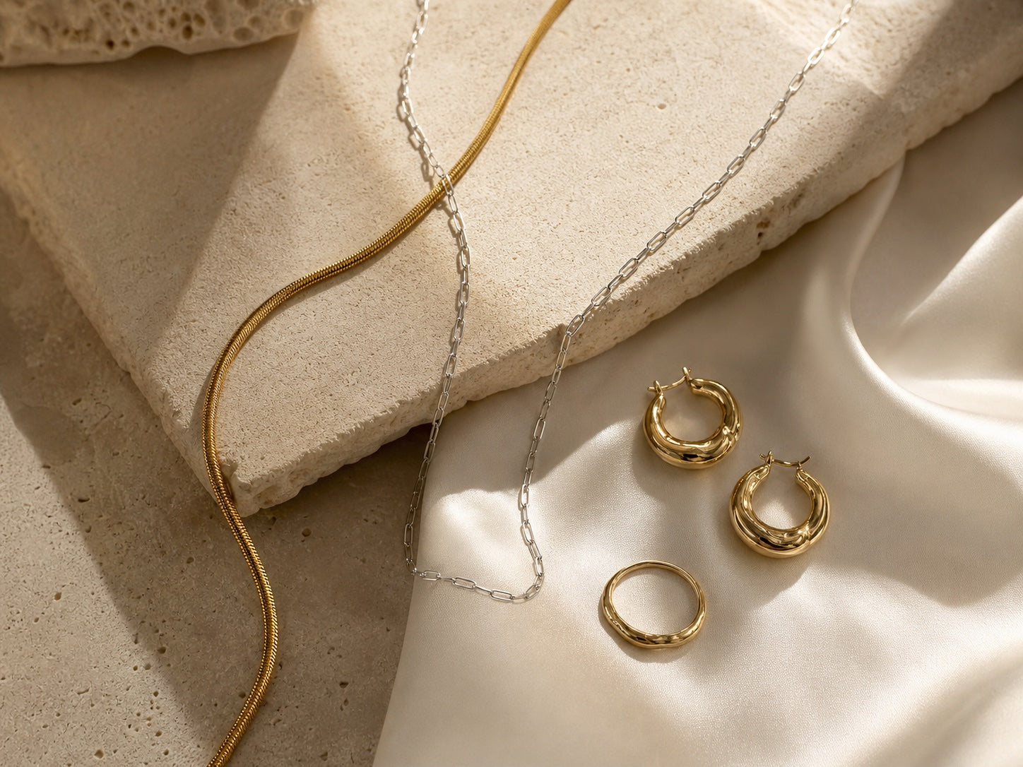 Gold and silver jewelry styled on ivory stone and silk
