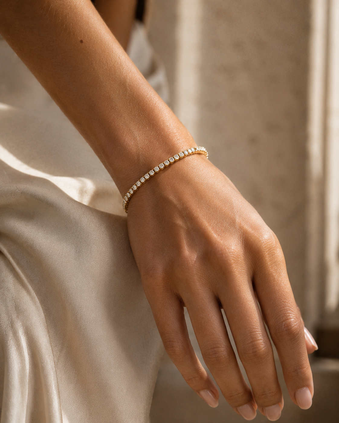 Model wearing a gold-tone tennis bracelet