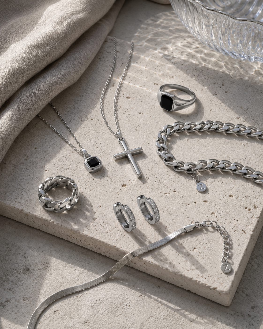 Silver-tone Zyvora jewelry arranged on warm stone
