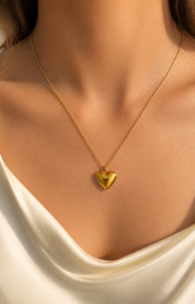 Model wearing Cora Heart Pendant in gold [finish:gold]