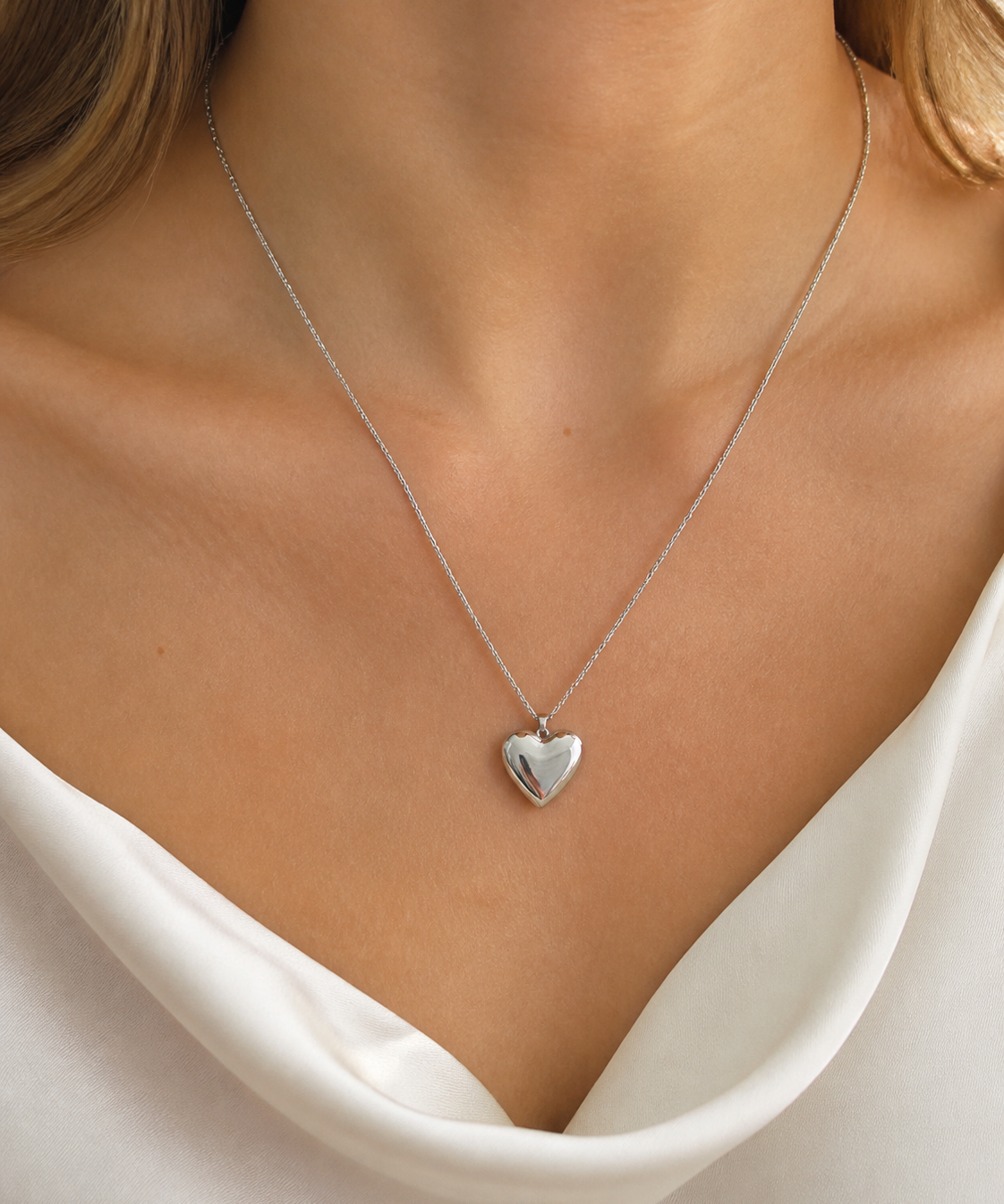 Model wearing Cora Heart Pendant in silver [finish:silver]