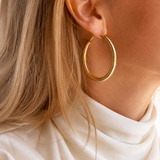 Model wearing Evara Statement Hoops in gold [finish:gold]