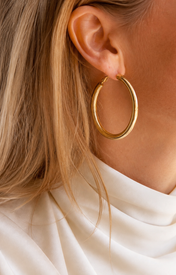 Model wearing Evara Statement Hoops in gold [finish:gold]