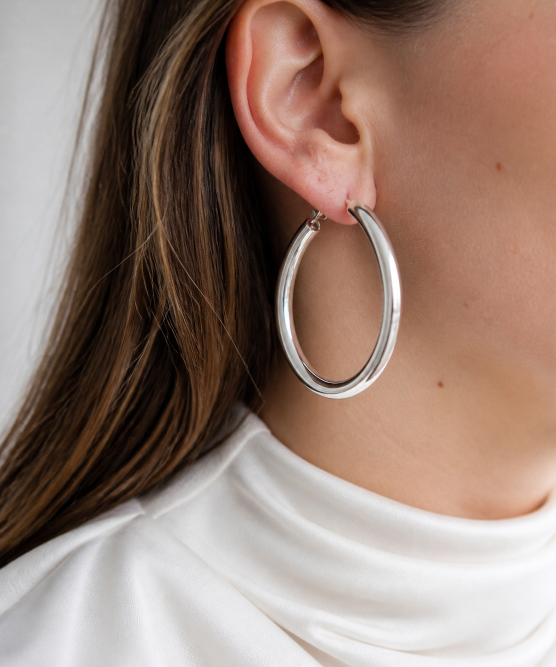 Model wearing Evara Statement Hoops in silver [finish:silver]