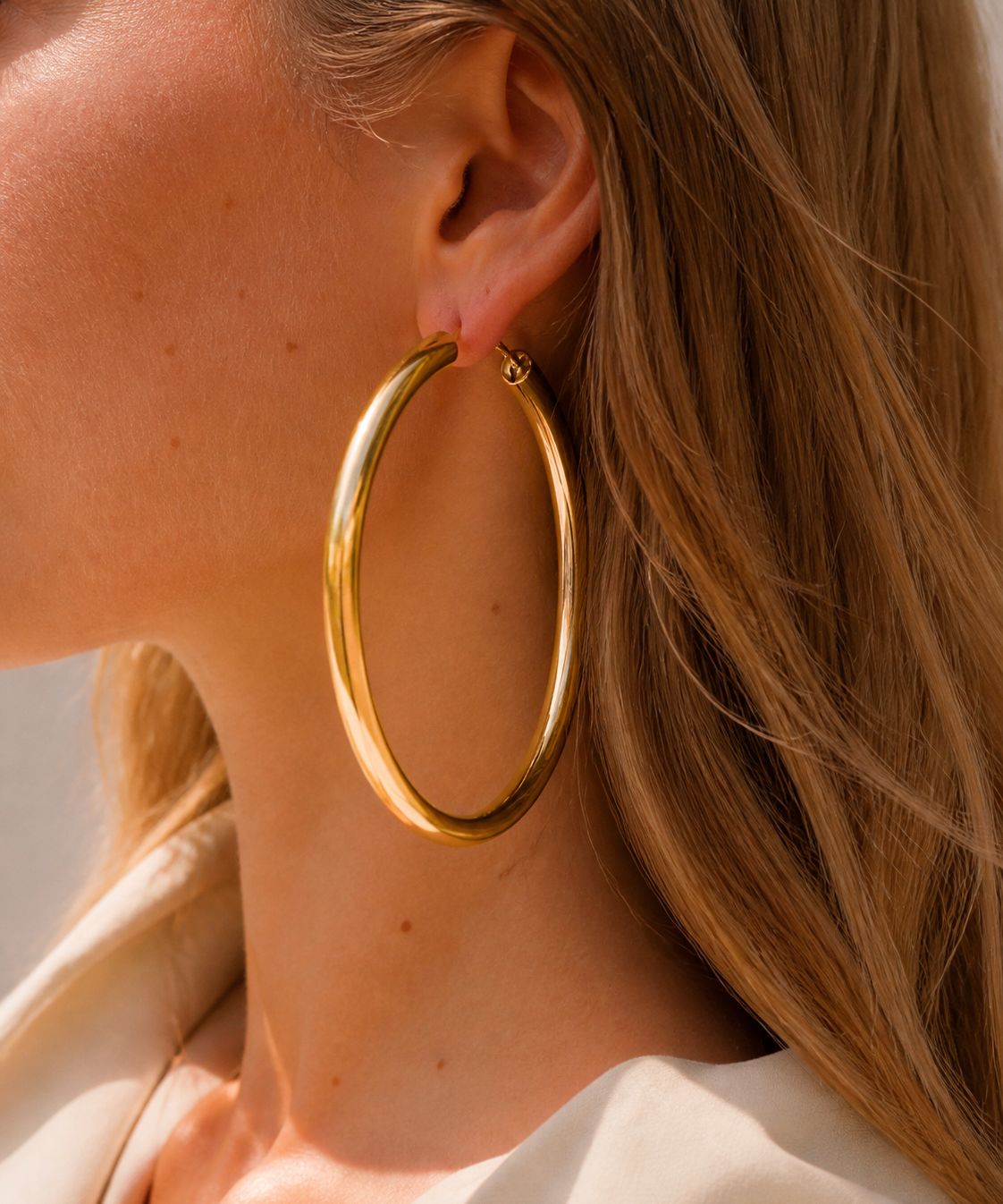 Model wearing Evara XL Hoops in gold [finish:gold]