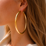 Model wearing Evara XL Hoops in gold [finish:gold]