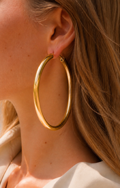 Model wearing Evara XL Hoops in gold [finish:gold]