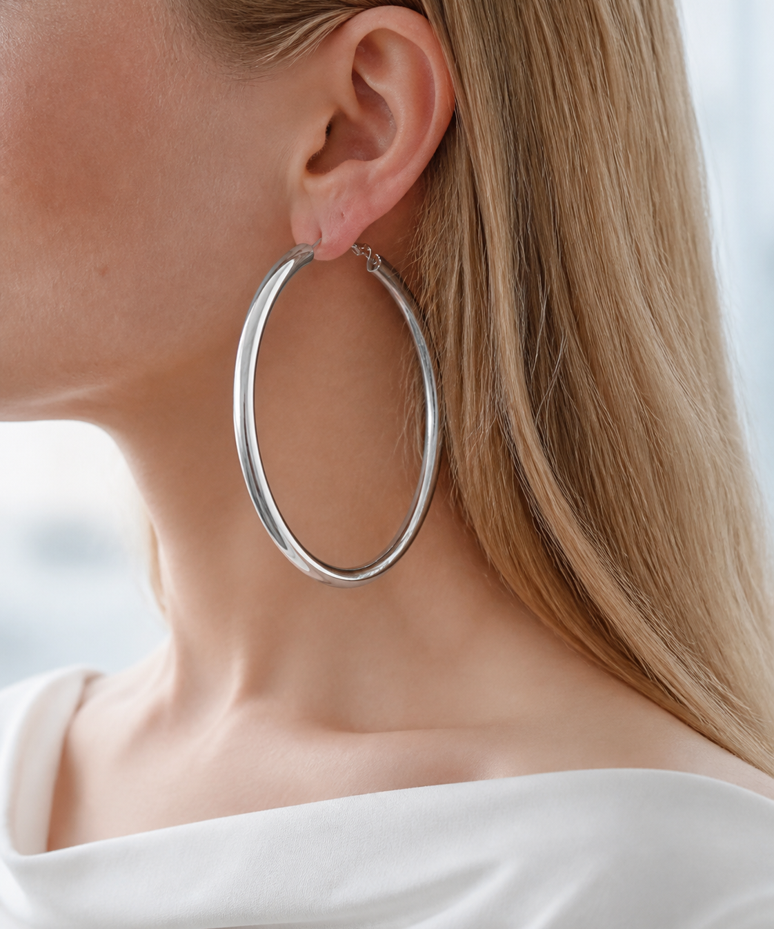 Model wearing Evara XL Hoops in silver [finish:silver]