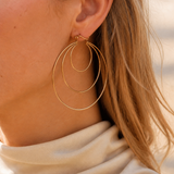 Model wearing Aurea Spiral Earrings in gold [finish:gold]