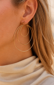 Model wearing Aurea Spiral Earrings in gold [finish:gold]