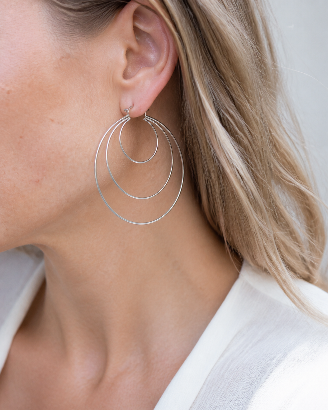 Model wearing Aurea Spiral Earrings in silver