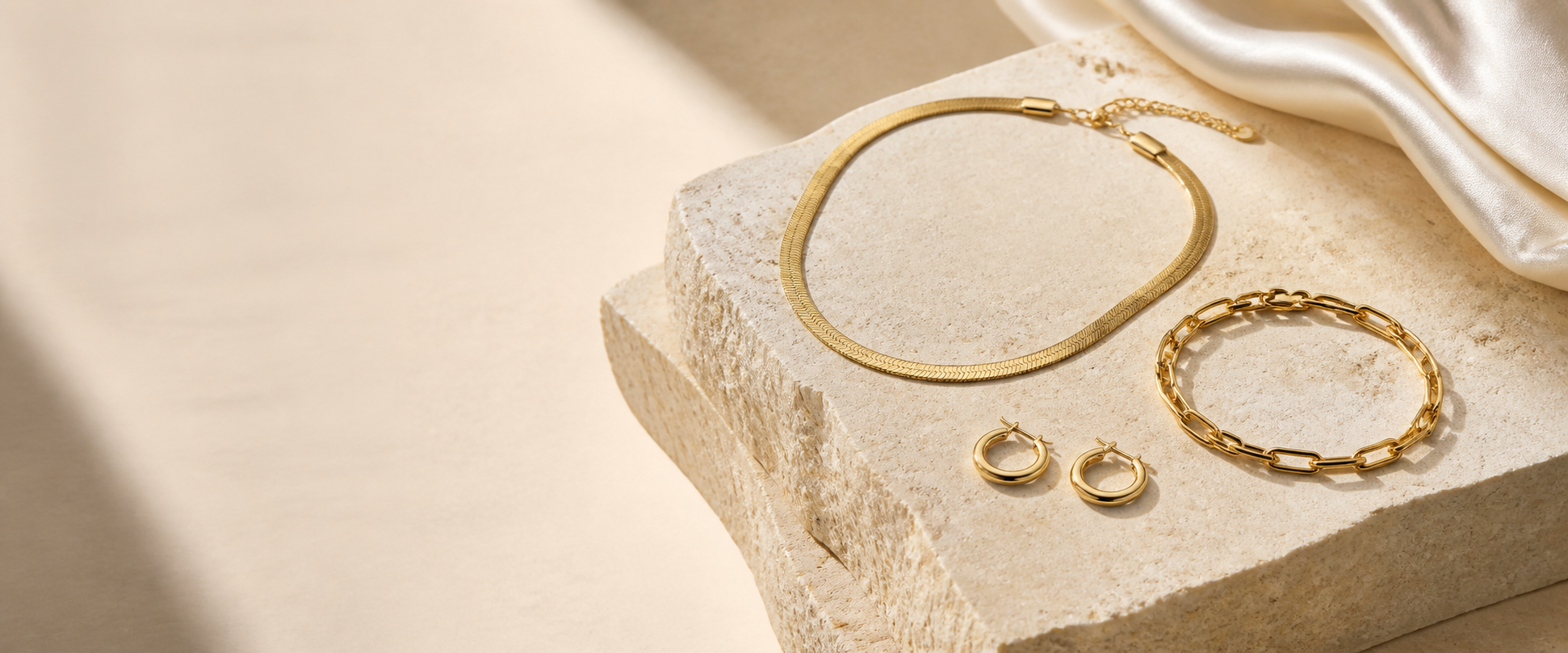 Three Zyvora jewelry pieces arranged on ivory stone